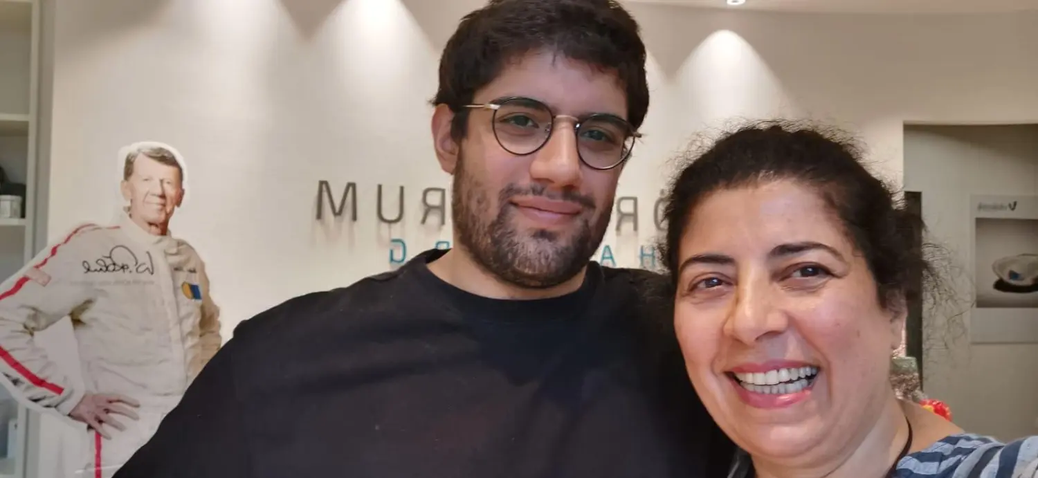 Cansu-Meric Gökdemir – Hörzentrum Süderelbe – zwei Personen lächeln in einem Innenraum vor einer Wandtafel.