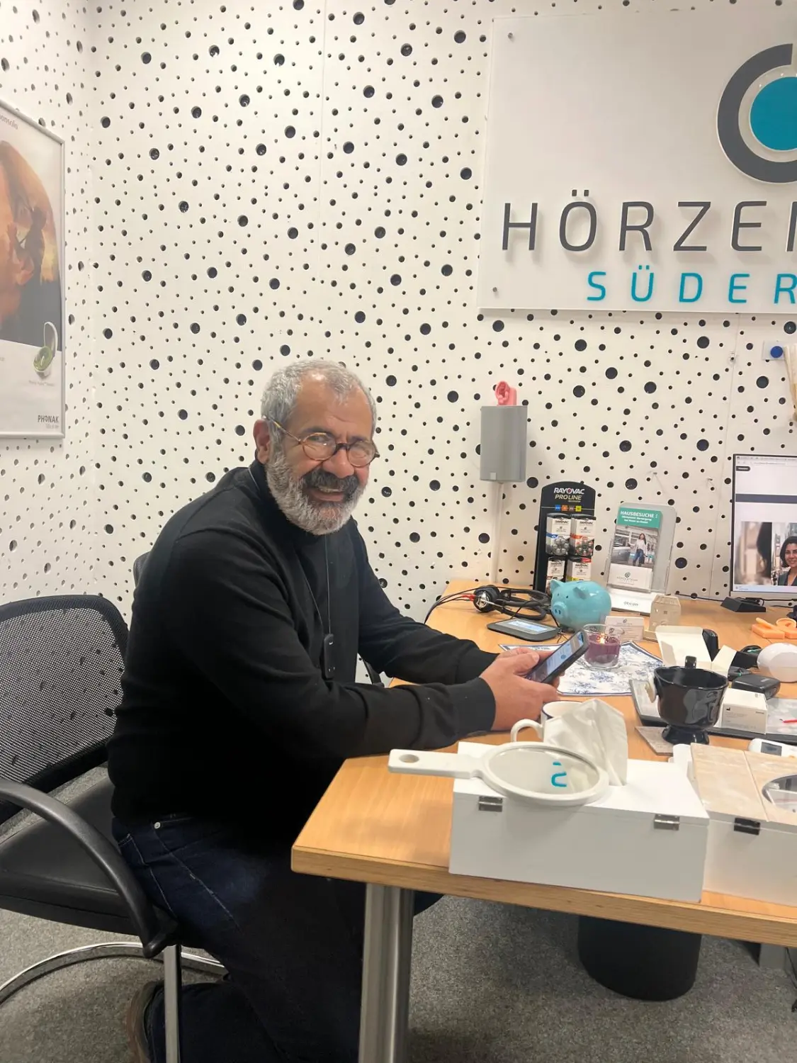 Cansu-Meric Gökdemir – Hörzentrum Süderelbe – ein silberner Opel Corsa parkt auf einer gepflasterten Fußgängerzone neben einem Wegweiser in einer europäischen Stadt