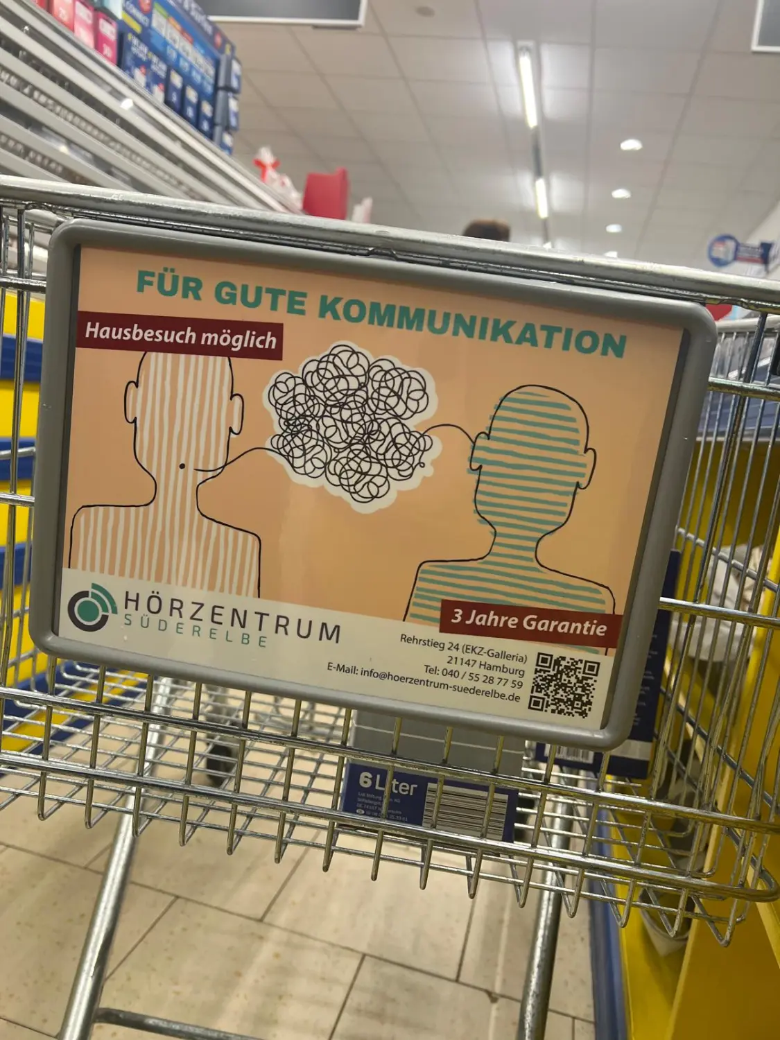 Cansu-Meric Gökdemir – Hörzentrum Süderelbe – ein Werbeschild an einem Einkaufswagen für das Hörzentrum Süderelbe, ein Hörzentrum in Hamburg